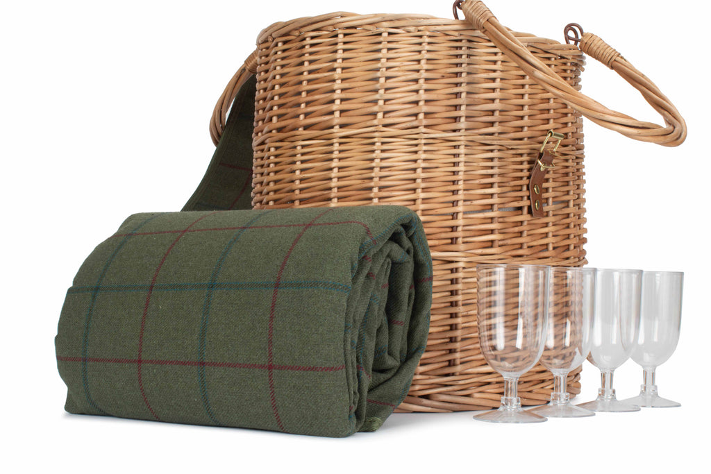 Wicker picnic basket with green plaid blanket and wine glasses on a white background
