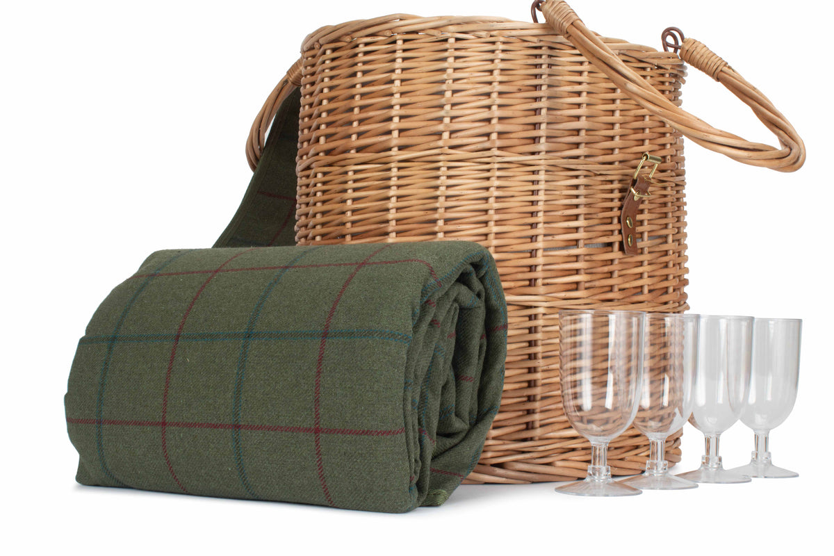 Wicker picnic basket with green plaid blanket and wine glasses on a white background