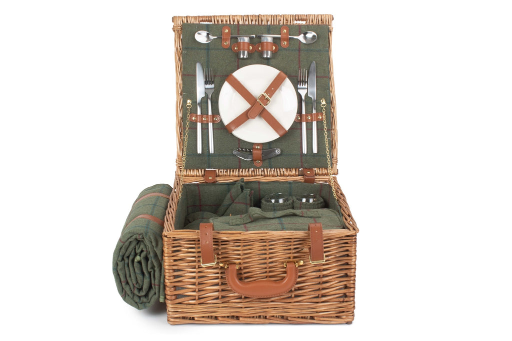 Open picnic basket with green interior, cutlery, and a blanket on a white background
