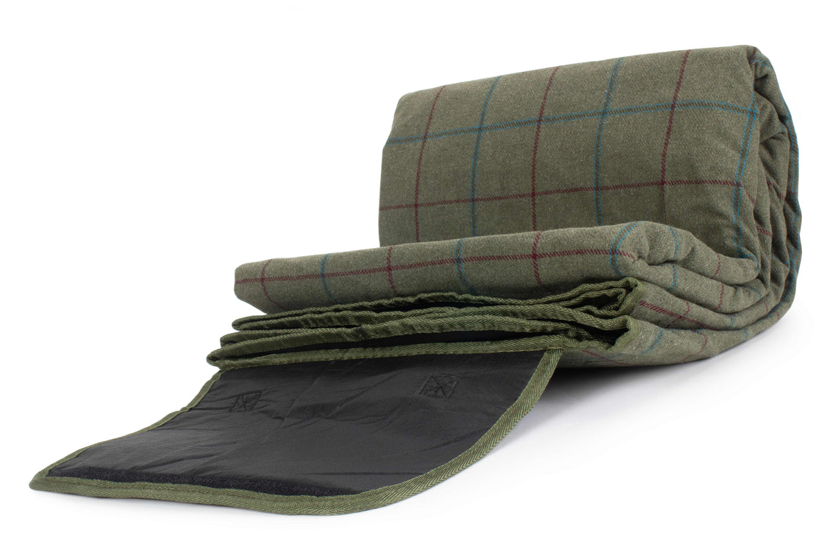 Folded green plaid blanket on a white background